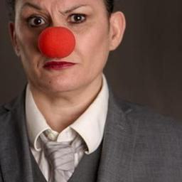 Portrait de Sandrine Rastello en complet gris avec un nez de clown rouge, affiche du spectacle Double Vie